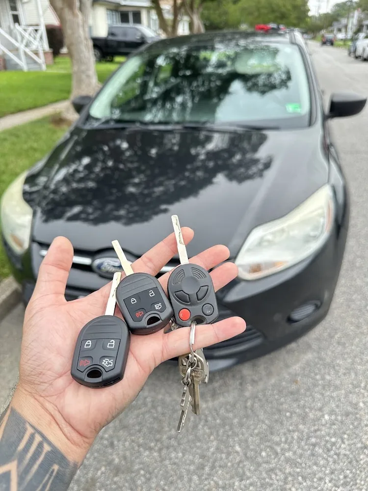 Replacement car key fobs in front of a Ford vehicle