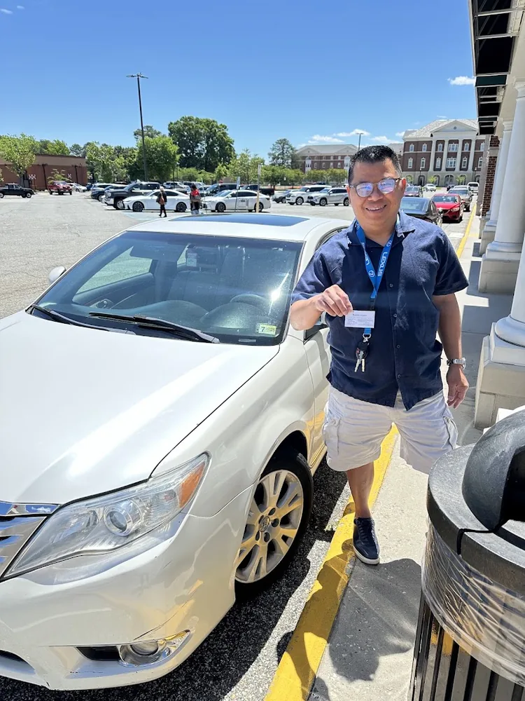Customer holding a new car key outside a shopping center